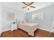 Charming bedroom with hardwood floors, a comfortable bed, a ceiling fan, and a sunlit window for a relaxing ambiance at 2106 Sherbrook Dr, Valrico, FL 33594