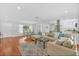 Bright open-concept living space featuring hardwood floors, modern decor, and seamless flow to the kitchen at 2106 Sherbrook Dr, Valrico, FL 33594