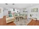 Spacious living room with a large sectional sofa, hardwood floors, and a view of the modern kitchen at 2106 Sherbrook Dr, Valrico, FL 33594