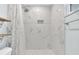 Modern shower with elegant marble tiling, rainfall showerhead, and contrasting black and white tiled floor at 2106 Sherbrook Dr, Valrico, FL 33594