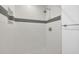 Modern shower featuring white subway tile with a gray accent stripe at 2106 Sherbrook Dr, Valrico, FL 33594