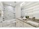 Bathroom with a bathtub, toilet and granite double sink vanity with a large framed mirror at 2405 W North B St # 1, Tampa, FL 33609