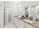 Bright bathroom featuring a double granite vanity, white cabinets, and a walk-in shower at 2405 W North B St # 1, Tampa, FL 33609