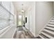Bright foyer features wood-look flooring, a modern light fixture, and staircase at 2405 W North B St # 1, Tampa, FL 33609