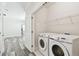 Bright laundry area featuring a washer and dryer and spacious shelving and access to the bedroom at 2405 W North B St # 1, Tampa, FL 33609
