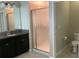 Bathroom view featuring a tiled shower with patterned glass, dark vanity, and toilet at 2588 Bartolo Dr, Land O Lakes, FL 34639