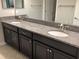 Modern bathroom with dark cabinets, granite countertops, double sinks, and sleek fixtures at 2588 Bartolo Dr, Land O Lakes, FL 34639