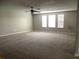Spacious living room with neutral carpet, fan, and natural light from multiple windows at 2588 Bartolo Dr, Land O Lakes, FL 34639