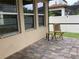 Outdoor patio with stylish brick flooring, a chair, and access to the screened lanai at 2588 Bartolo Dr, Land O Lakes, FL 34639