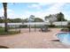 Community pool area with a brick paver deck, lounge chairs and perimeter fencing at 2588 Bartolo Dr, Land O Lakes, FL 34639