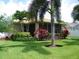 Backyard featuring a covered lanai, vibrant landscaping, and lush green grass at 27810 Sky Lake Cir, Wesley Chapel, FL 33544