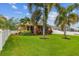 Lush backyard featuring palm trees, manicured landscaping, and a white fence at 27810 Sky Lake Cir, Wesley Chapel, FL 33544