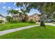Landscaped front yard of home with lawn, plants, palms, and driveway at 27810 Sky Lake Cir, Wesley Chapel, FL 33544