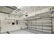 Interior garage view with overhead storage racks and a white garage door at 27810 Sky Lake Cir, Wesley Chapel, FL 33544