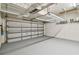 View of the garage interior with storage racks, garage door, and painted floor at 27810 Sky Lake Cir, Wesley Chapel, FL 33544