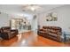 Open living area with view of kitchen and dining space, featuring hardwood floors and comfortable seating at 27810 Sky Lake Cir, Wesley Chapel, FL 33544