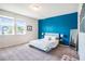 Bright bedroom with a blue accent wall, large windows, and soft carpet at 2919 Grand Kemerton Pl, Tampa, FL 33618