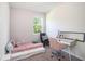 Cozy bedroom with a trundle bed, desk, accent chair, and natural light from the window at 2919 Grand Kemerton Pl, Tampa, FL 33618