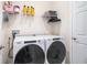 Laundry room with a white, front-load washing machine and dryer set, and shelf space above at 2919 Grand Kemerton Pl, Tampa, FL 33618