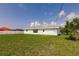 A green lawn stretches back to the home, which is accented by a vibrant green tree on the right side at 3316 Port Charlotte Blvd, Port Charlotte, FL 33952