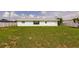 A sprawling green backyard provides ample space, set off by the pale-blue exterior of the home at 3316 Port Charlotte Blvd, Port Charlotte, FL 33952