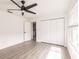 This bright bedroom features wood floors, neutral walls, a ceiling fan, and a closet for optimal storage at 3316 Port Charlotte Blvd, Port Charlotte, FL 33952