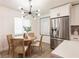 Bright dining area with a round table, modern chandelier, stainless steel fridge, and stylish decor at 3316 Port Charlotte Blvd, Port Charlotte, FL 33952