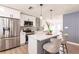 Modern kitchen featuring stainless steel appliances, white cabinets, a stylish island with bar stools and pendant lights at 3316 Port Charlotte Blvd, Port Charlotte, FL 33952