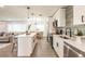 Open-concept kitchen with a modern island, stainless steel appliances, and a view into the dining and living areas at 3316 Port Charlotte Blvd, Port Charlotte, FL 33952