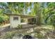 View of the carport and sunroom featuring mature landscaping, a fire pit, and a serene backyard at 3709 W San Pedro St, Tampa, FL 33629