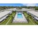 Overhead shot of a community pool and deck area surrounded by green lawns and residential buildings at 4160 Fruitville Rd # 77, Sarasota, FL 34232