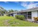 Back exterior of light gray condos showcasing a shared lawn space at 4160 Fruitville Rd # 77, Sarasota, FL 34232