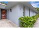 Light gray condo exterior with a black entry door and green shrubbery at 4160 Fruitville Rd # 77, Sarasota, FL 34232