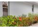Exterior view showcasing vibrant flowers and greenery against the light blue exterior wall of the building at 4160 Fruitville Rd # 77, Sarasota, FL 34232