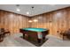 Spacious game room featuring a pool table with green felt, wood paneling, and laminate floors at 4160 Fruitville Rd # 77, Sarasota, FL 34232