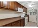 Well-maintained kitchen with white appliances, brown cabinets and countertops, and a window offering natural light at 4160 Fruitville Rd # 77, Sarasota, FL 34232