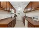 Functional kitchen featuring brown cabinets, white appliances, and ample counter space for meal preparation at 4160 Fruitville Rd # 77, Sarasota, FL 34232