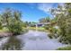 Scenic view of a tranquil pond with a fountain, surrounded by lush greenery and flowering trees at 4160 Fruitville Rd # 77, Sarasota, FL 34232