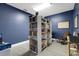 Relaxing reading room with floor-to-ceiling bookshelf, blue accent wall, and light laminate floors at 4160 Fruitville Rd # 77, Sarasota, FL 34232