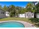 Backyard view showcasing sparkling pool, fenced yard, landscaping, and shed for extra storage at 5107 W Platt St, Tampa, FL 33609