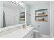 Bright bathroom featuring a marble vanity, modern fixtures, and built-in shelving for optimal organization at 5107 W Platt St, Tampa, FL 33609