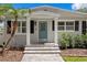 Inviting entryway with a charming blue door, decorative sidelights, and a well-maintained walkway at 5107 W Platt St, Tampa, FL 33609