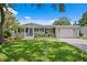 Charming single-story home with well-manicured lawn, lush landscaping, and a paved driveway at 5107 W Platt St, Tampa, FL 33609