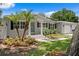 Charming home featuring a well-manicured lawn, lush landscaping and mature trees at 5107 W Platt St, Tampa, FL 33609