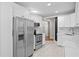 Well-lit kitchen equipped with stainless steel appliances, white cabinets, and a stylish tile floor at 5107 W Platt St, Tampa, FL 33609