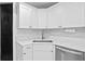 Kitchen featuring white cabinets, white marble countertops and bronze fixtures at 5107 W Platt St, Tampa, FL 33609