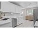 Bright kitchen features white cabinets, marble countertops, subway tile backsplash, and stainless steel appliances at 5107 W Platt St, Tampa, FL 33609