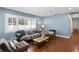 Bright and stylish living room showcasing hardwood floors and ample natural light through shuttered windows at 5107 W Platt St, Tampa, FL 33609