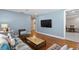 Open living room with hardwood floors, a television, and a view to additional living spaces at 5107 W Platt St, Tampa, FL 33609
