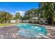 Inviting backyard pool surrounded by lush tropical landscaping, white fencing, and brick pavers at 5107 W Platt St, Tampa, FL 33609